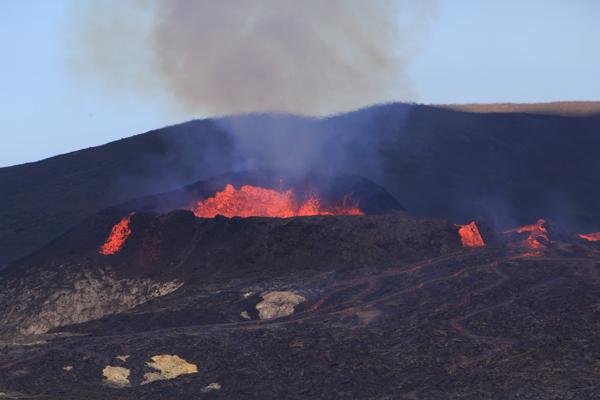 Lava erupting from a volcanic crater with glowing lava flows Iceland