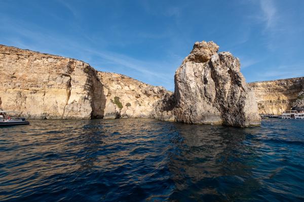 Towering coastal rock off a Mediterranean shore Għajnsielem, Malta